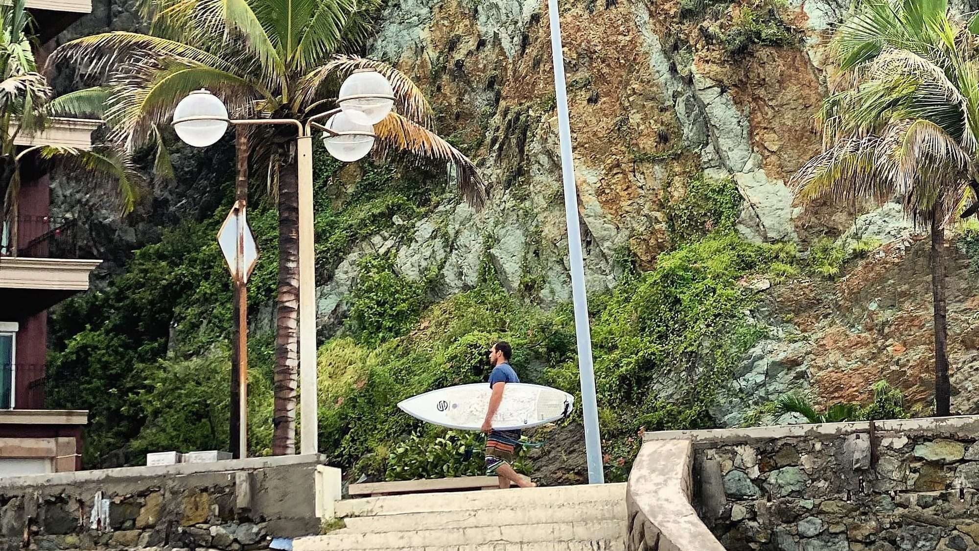 Un surfista camina hacia el mar en Olas Altas, Mazatlán